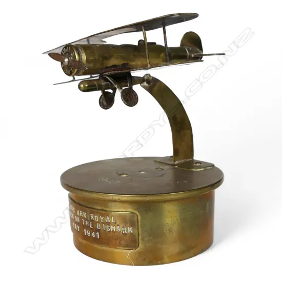 An old brass trench art bi-plane on large shell base,