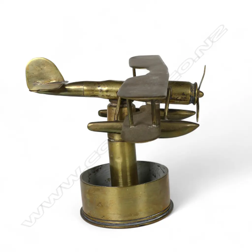 An old brass trench art float bi-plane on large shell cartridge end base, Image 1++