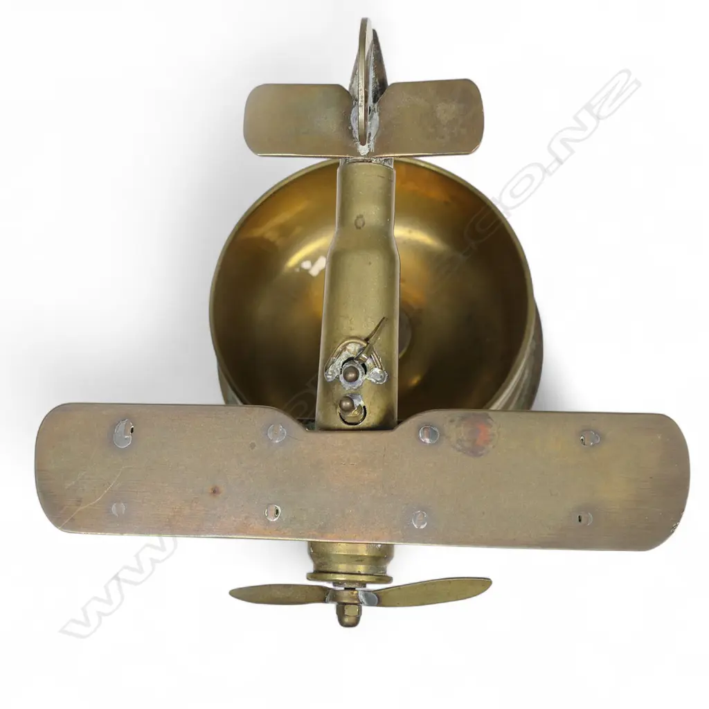 An old brass trench art float bi-plane on large shell cartridge end base, Image 1++
