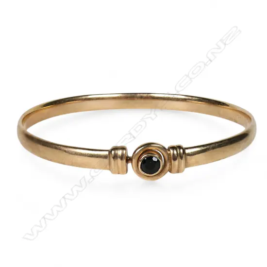 A 9ct rose gold and gem set sprung bangle,