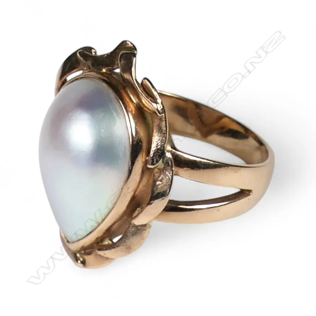 A 9ct rose gold and mabé pearl ring a pear shape mabé pearl (pink tone with green/blue nacre) bezel set with curved tapering bars comprising the frame. Ring size R. Stamped KARA. Valuation available. Image 1++
