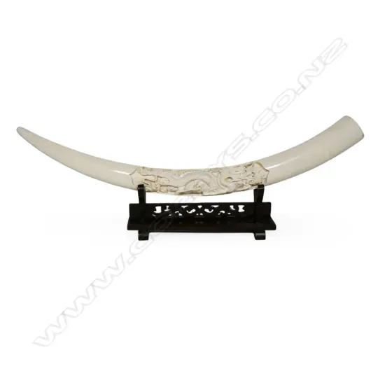 An ivory tusk with carved decoration,