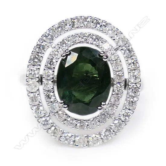 A 14ct white gold green sapphire and diamond double halo ring,