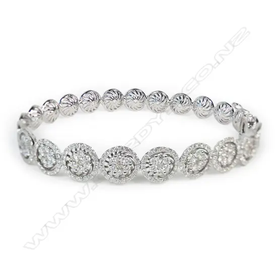 An 18ct white gold and multi diamond bangle,