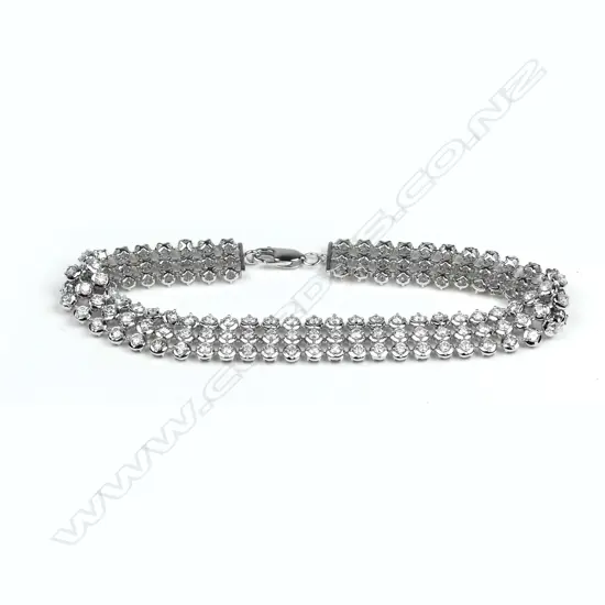 A modern 18ct. white gold and diamond triple band tennis type bracelet
