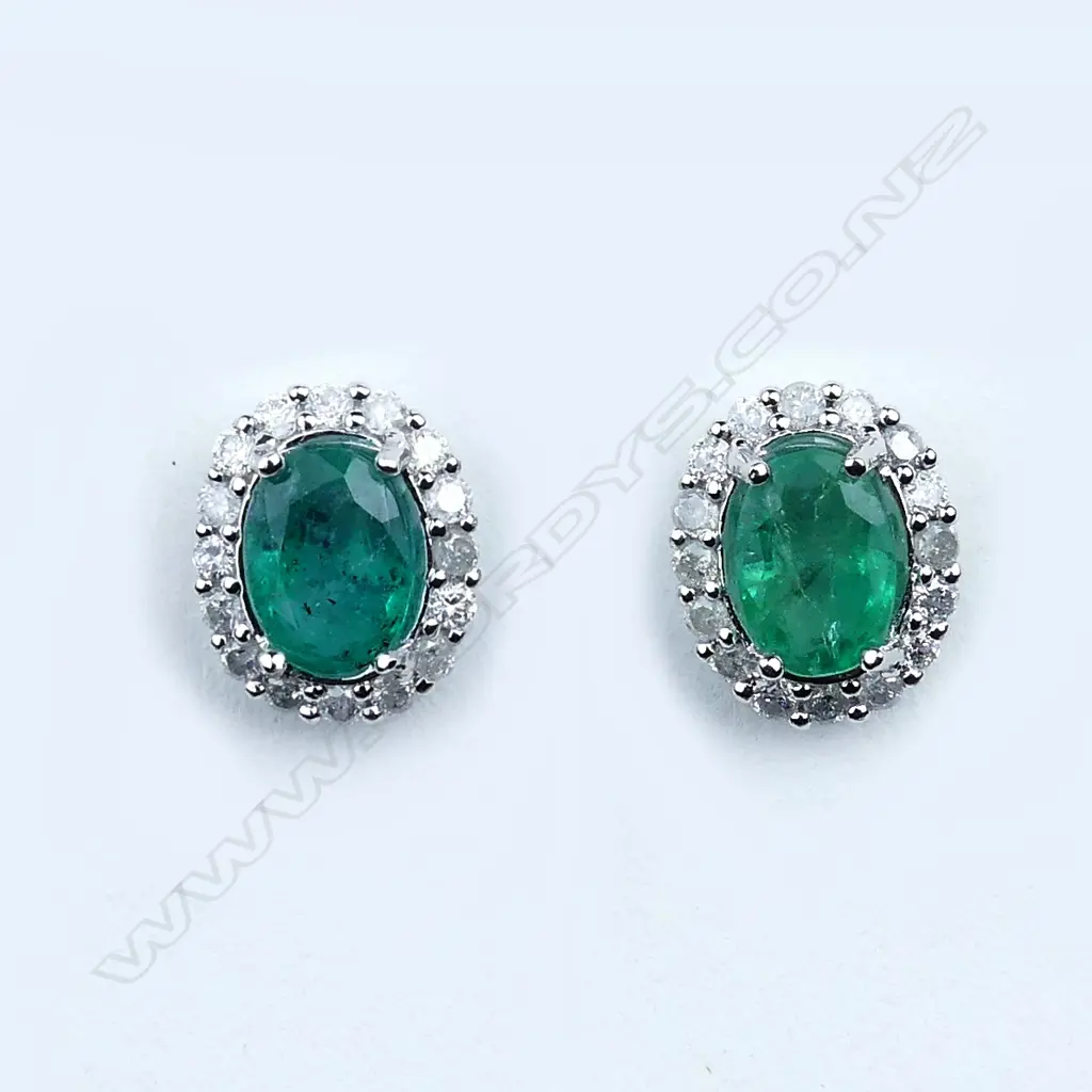 A pair of 14ct white gold emerald and diamond earrings Image 1++