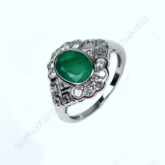 An 18ct white gold emerald and diamond ring