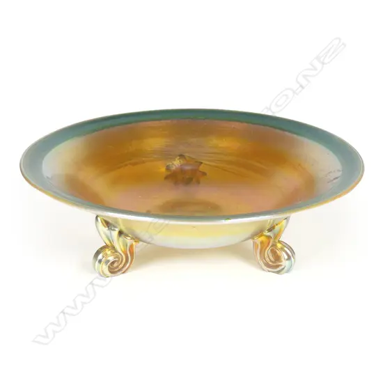 A Tiffany Favrile (green-gold) glass bowl raised on three scroll feet