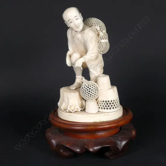 A Japanese Meiji period ivory okimono of a basket seller