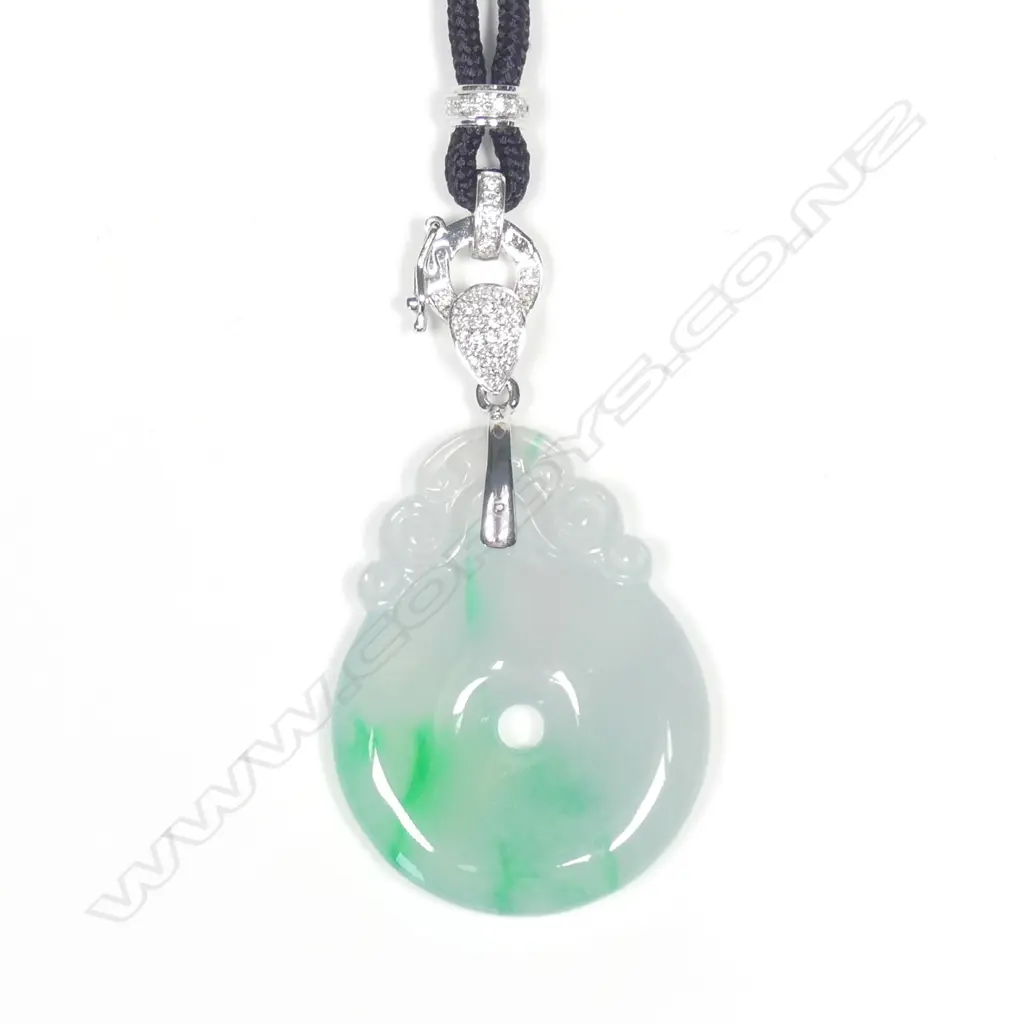A modern 18ct. white gold and diamond supported carved jadeite pendant Image 1++