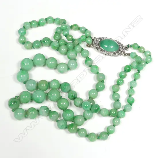 An early 20thC double strand jadeite bead necklace with gold and diamond clasp