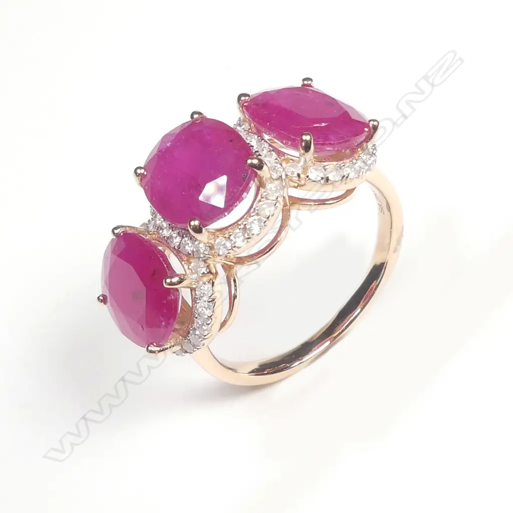 A 14ct rose gold ruby and diamond trilogy ring Image 1++