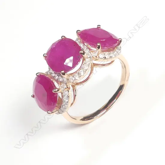 A 14ct rose gold ruby and diamond trilogy ring