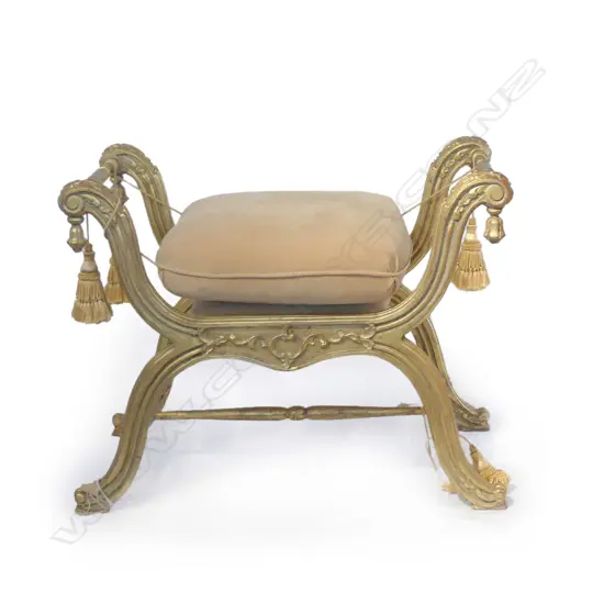 An ornate gilt curule stool