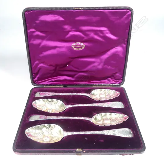 A boxed set of four silver berry spoons
