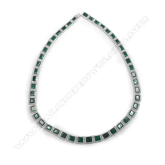 A platinum emerald and diamond halo necklace