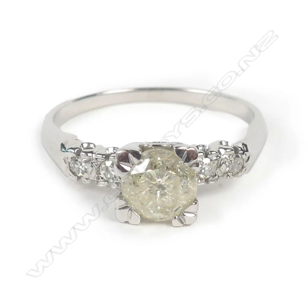 A 14ct white gold and diamond ring, a 0.74ct round brilliant cut diamond claw set with two brilliant cut diamonds to each shoulder, TDW 0.82ct. Valuation available. Image 1++