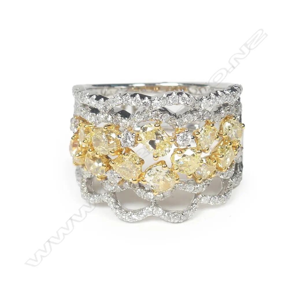 An 18ct. white gold fancy yellow and white diamond wide ring Image 1++