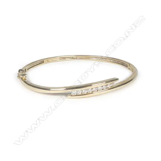 A 9ct yellow gold and nine diamond hinged bangle