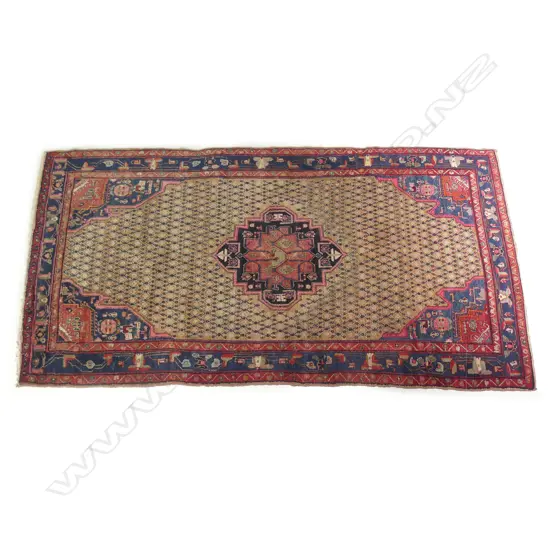 A large Persian carpet in traditional tones