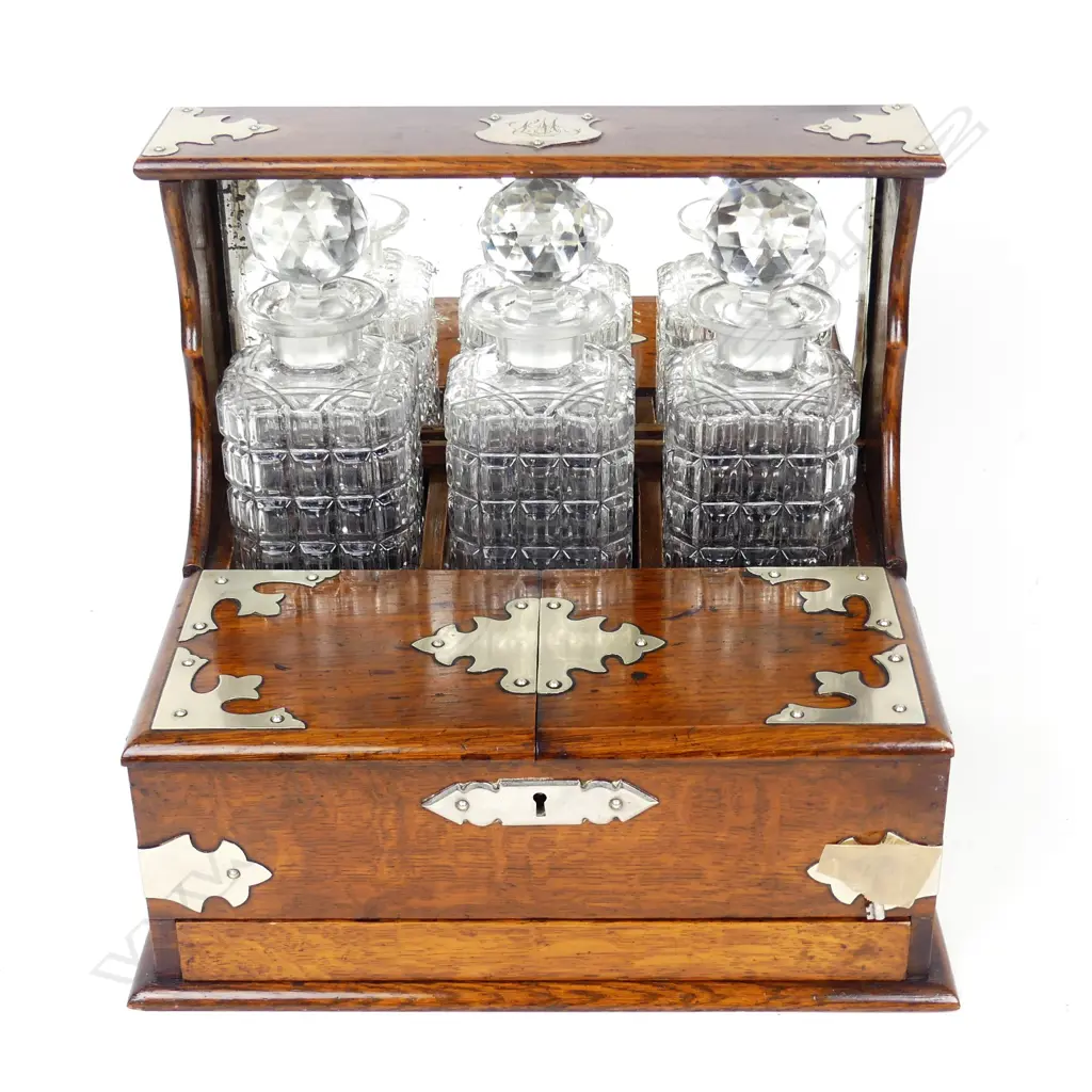 An Edwardian oak three-decanter tantalus Image 1++
