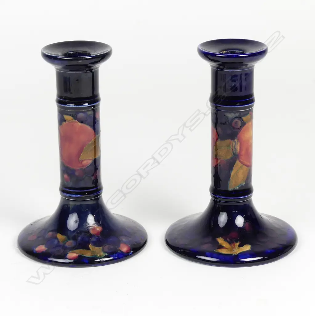A pair of William Moorcroft pomegranate decorated candlesticks Image 1++