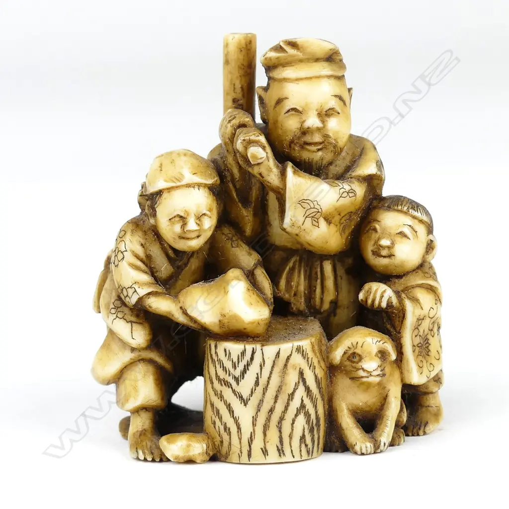A Meiji period ivory netsuke of a family group pounding mochi (sticky rice cake) Image 1++