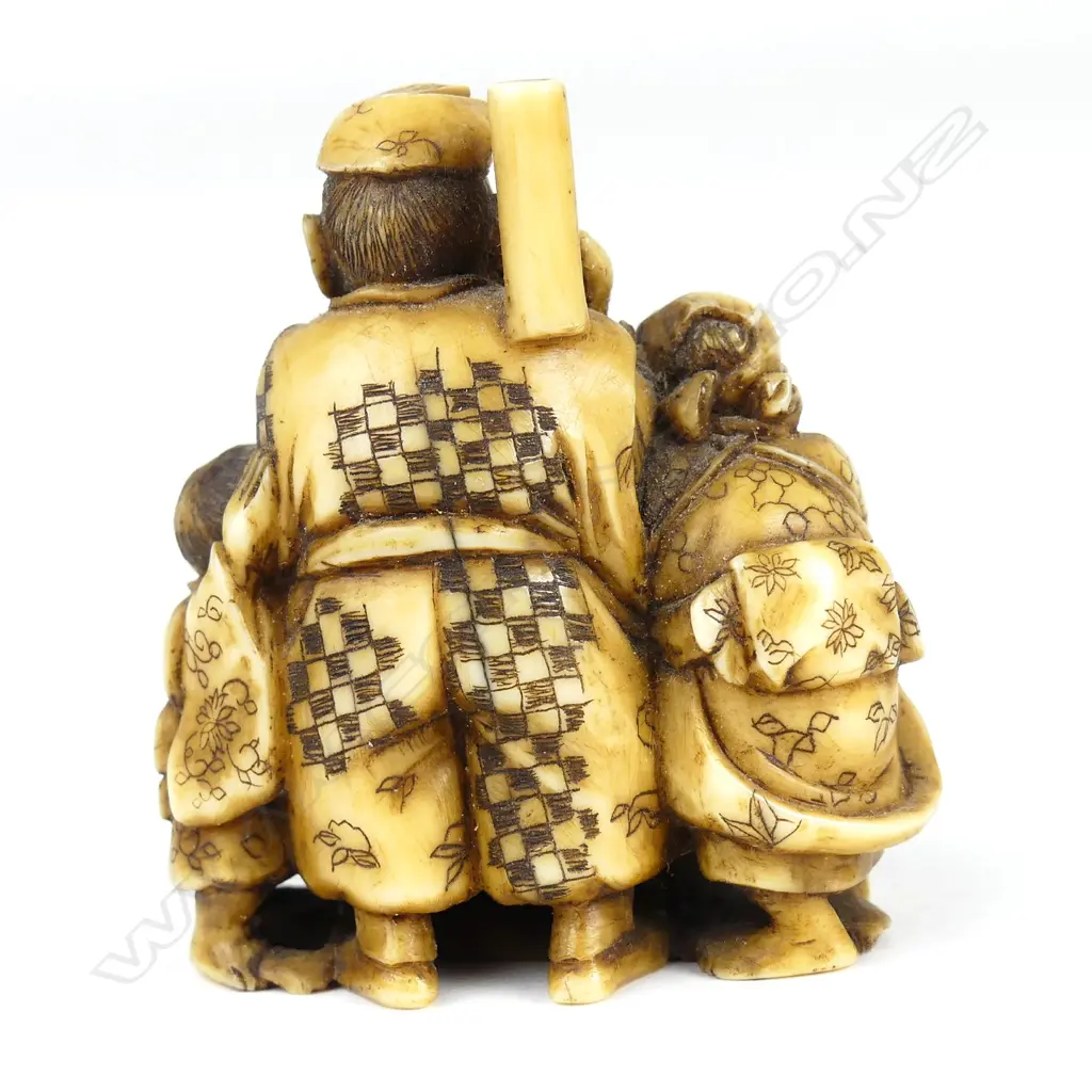 A Meiji period ivory netsuke of a family group pounding mochi (sticky rice cake) Image 1++