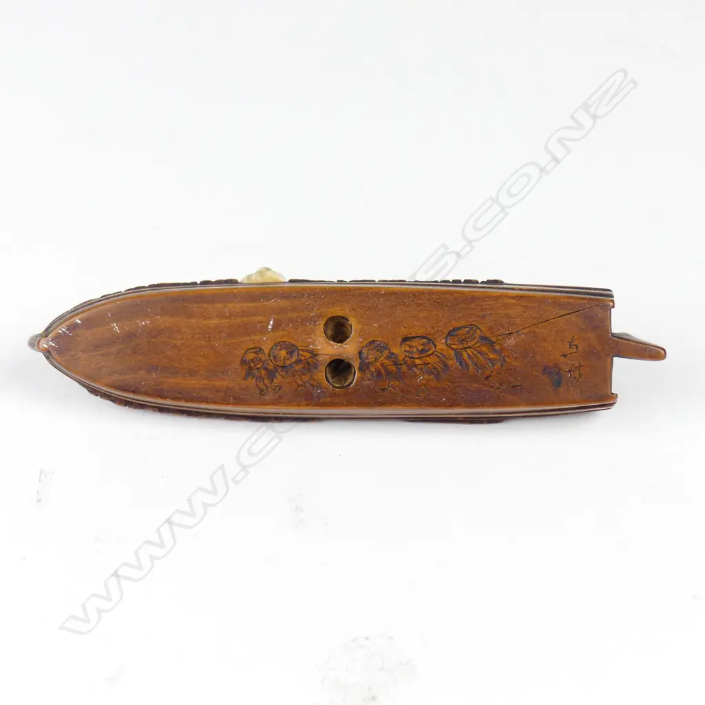 A Japanese boxwood and ivory netsuke of a figures relaxing on a sampan Image 1++