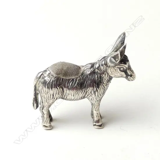 A small novelty Edwardian silver donkey pin cushion
