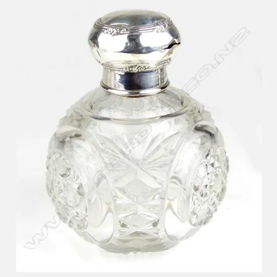An Edwardian silver topped large cut crystal scent bottle