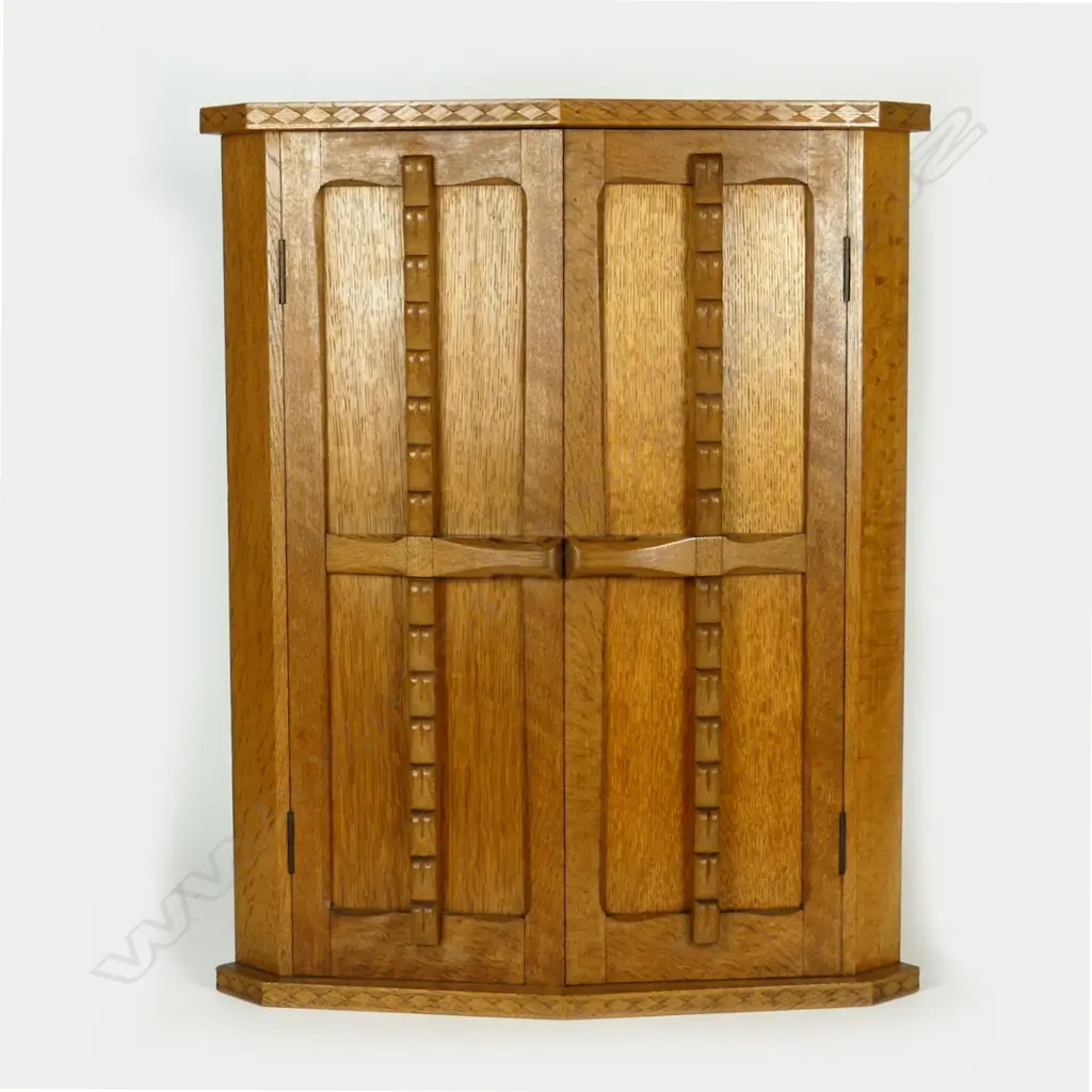 A mid 20thC oak Arts & Crafts carved oak hanging corner cupboard by Frederick Jackson Temperton Image 1++