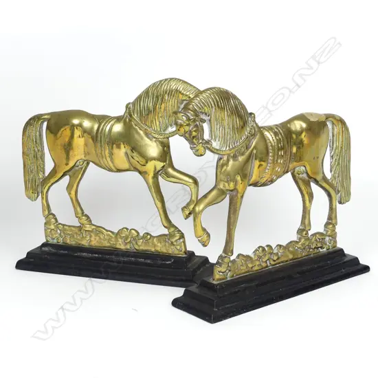A pair of old brass horse door stops