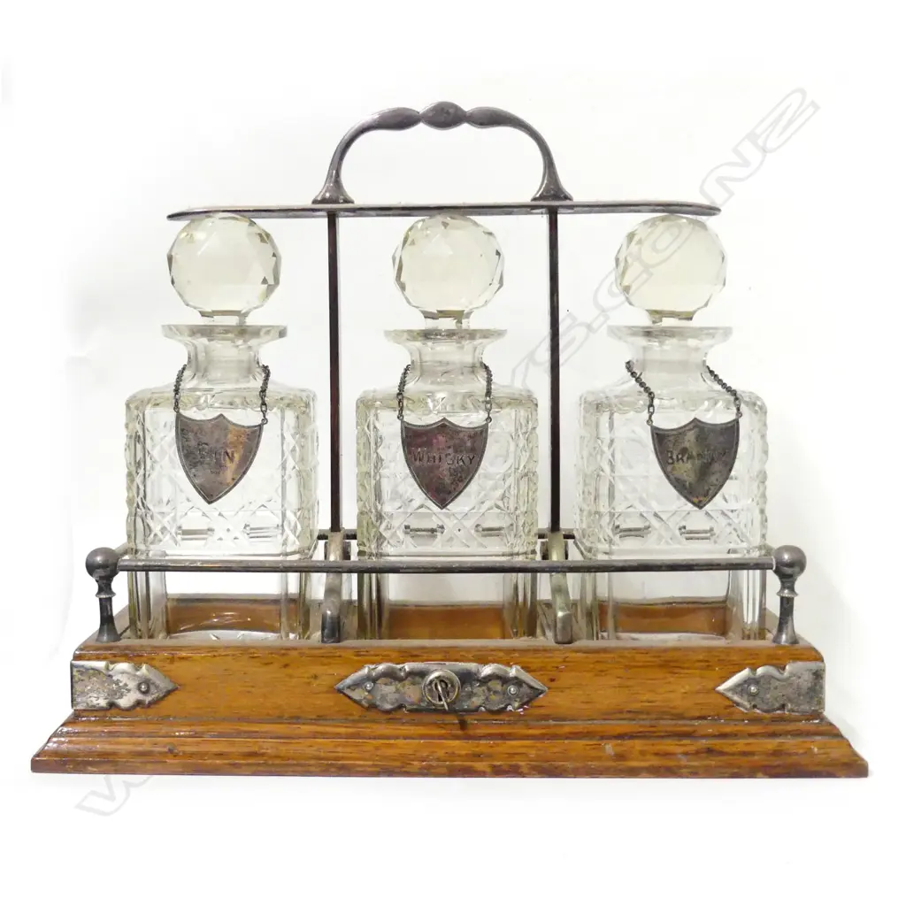 An Edwardian oak three-bottle tantalus Image 1++