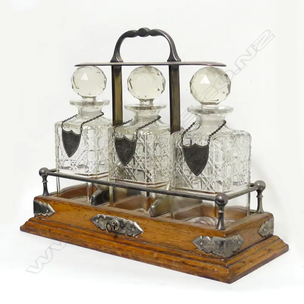 An Edwardian oak three-bottle tantalus Image 1++