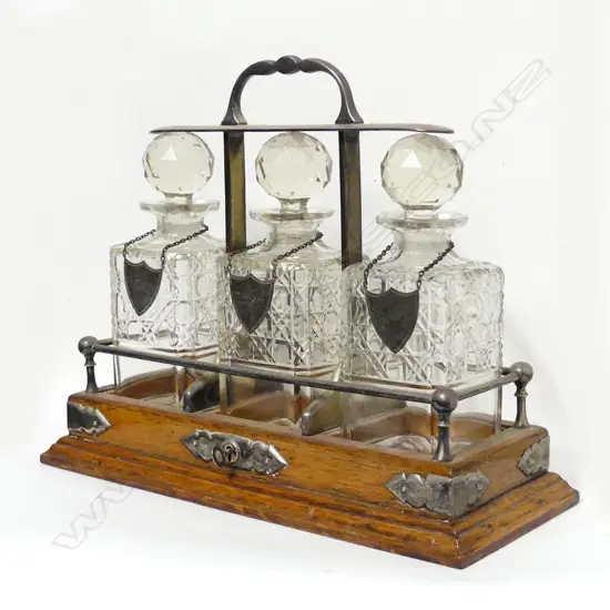 An Edwardian oak three-bottle tantalus