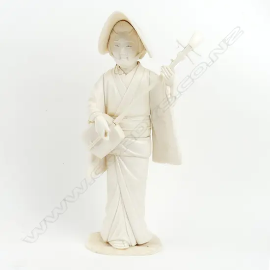 A Japanese sectional ivory figure of a strolling shamisen player