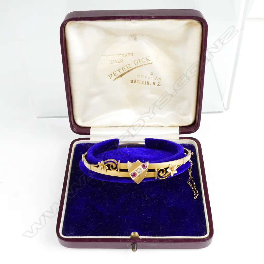An Edwardian 9ct. gold ruby and diamond hinged bangle Image 1++