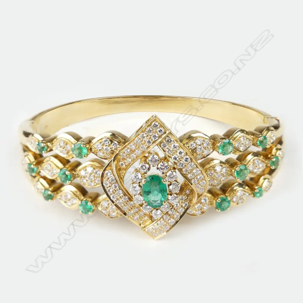 An 18ct gold emerald and diamond hinged bangle Image 1++