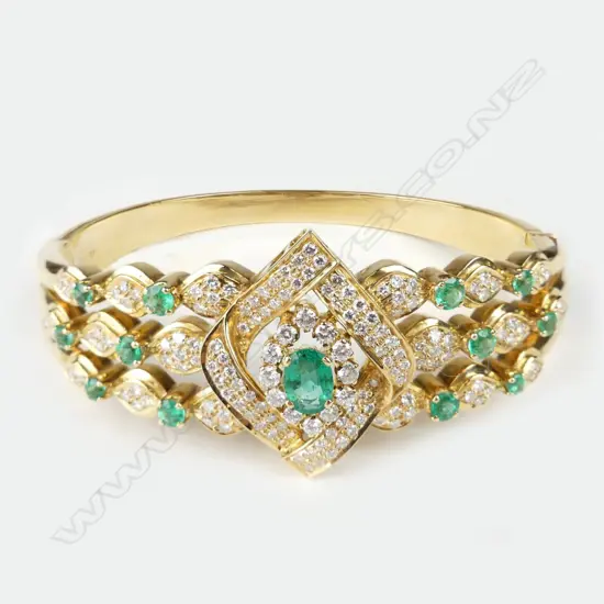 An 18ct gold emerald and diamond hinged bangle