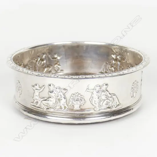 An uncommon George III silver decorated bottle coaster