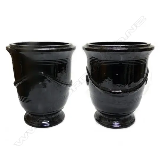 A pair of black glazed French 'Versailles' style garden urns