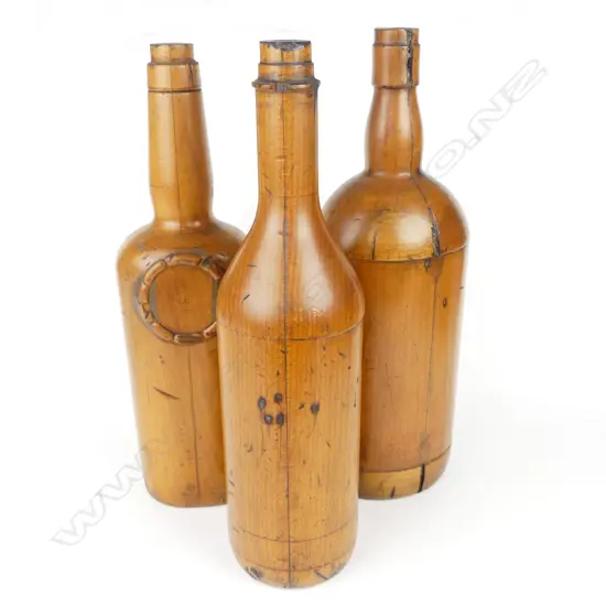 Three early 20thC turned kauri foundry moulds for spirit bottles