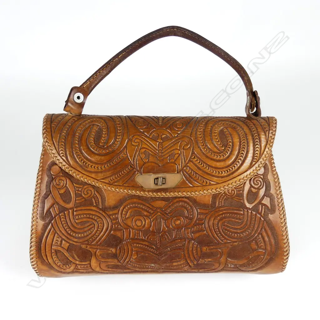 A leather handbag decoratively carved with Maori motifs Image 1++