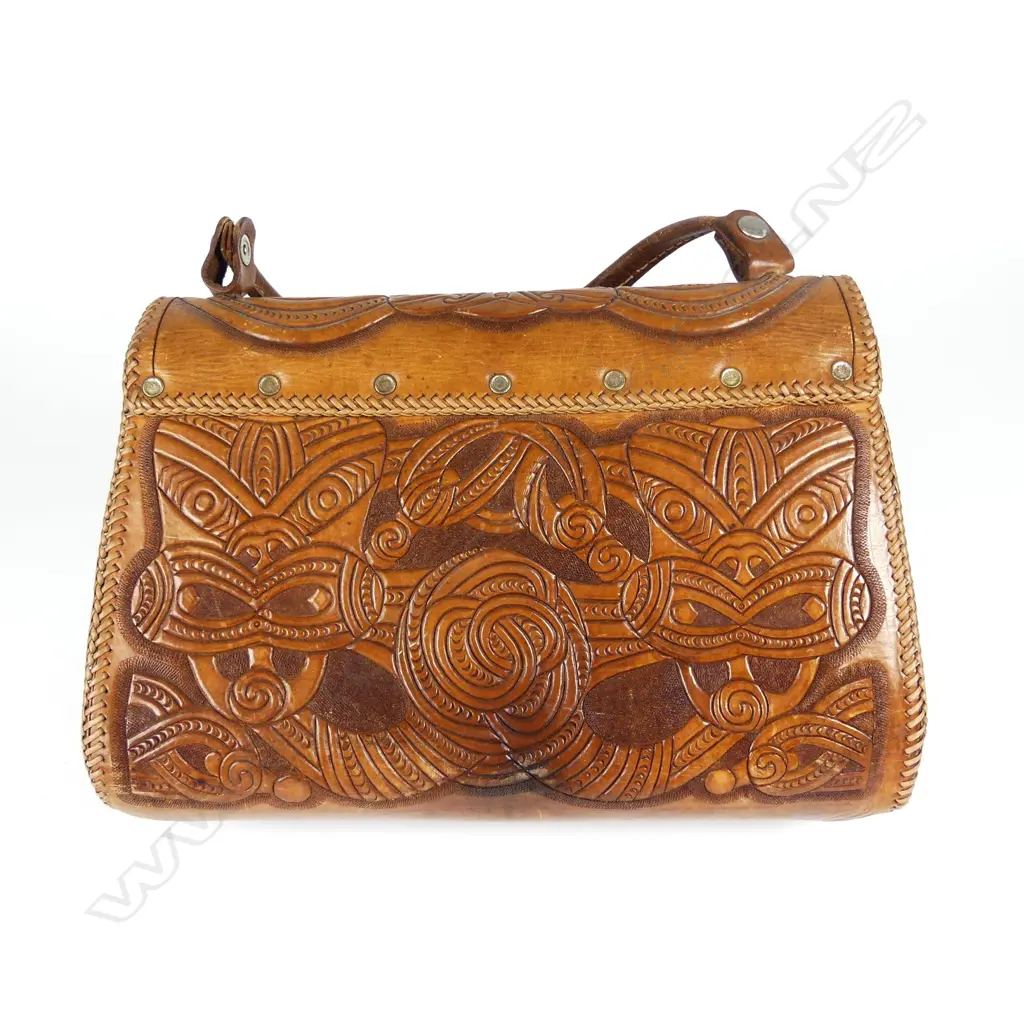 A leather handbag decoratively carved with Maori motifs Image 1++
