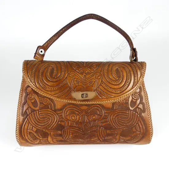 A leather handbag decoratively carved with Maori motifs