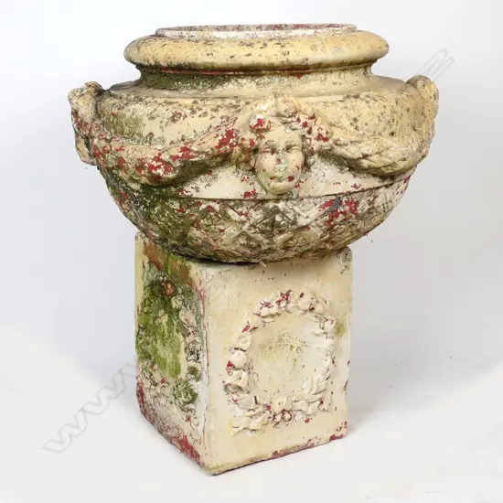 A large pottery garden urn on cube base