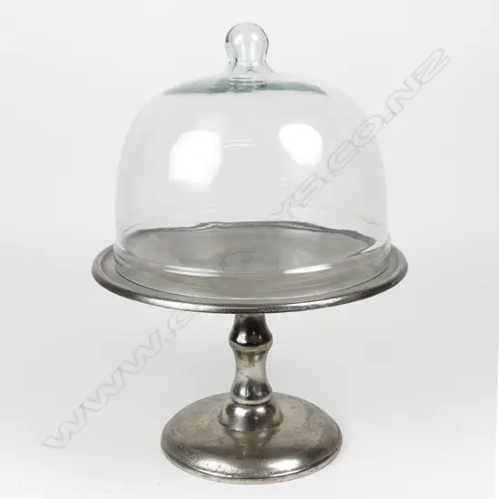 An aluminum cake stand with glass cover