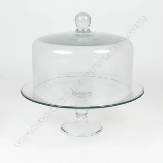 A clear glass cake stand and cover