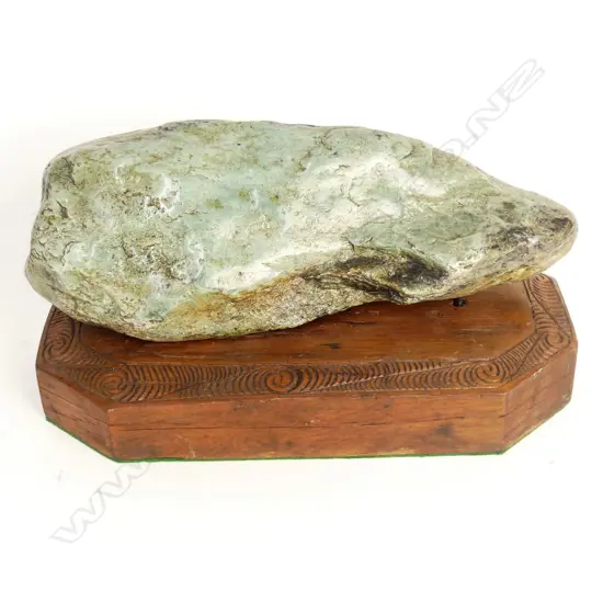 A pounamu boulder fixed to a Maori carved wooden plinth
